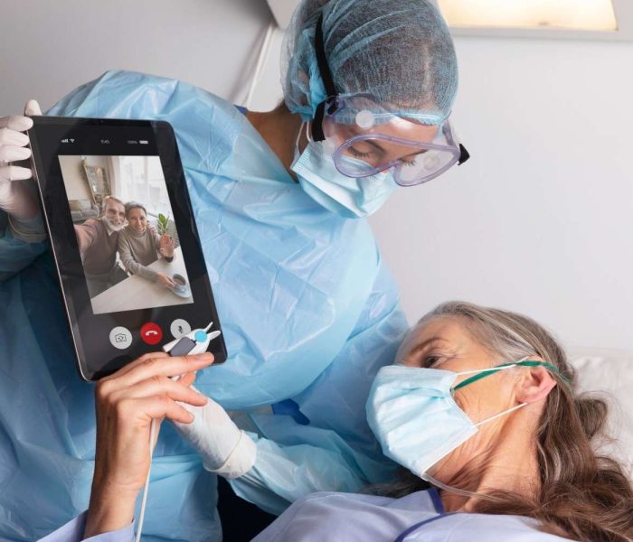 ill-female-patient-bed-hospital-talking-family-through-tablet (1)